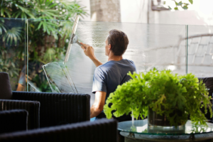 a man wiping a glass wall