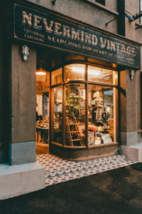 Clean sidewalk in front of a retail store with an illuminated window display and entrance.