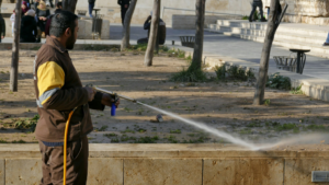 a man in brown using a pressure washer